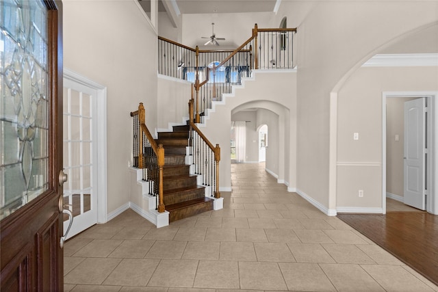 tiled foyer entrance featuring ceiling fan and ornamental molding