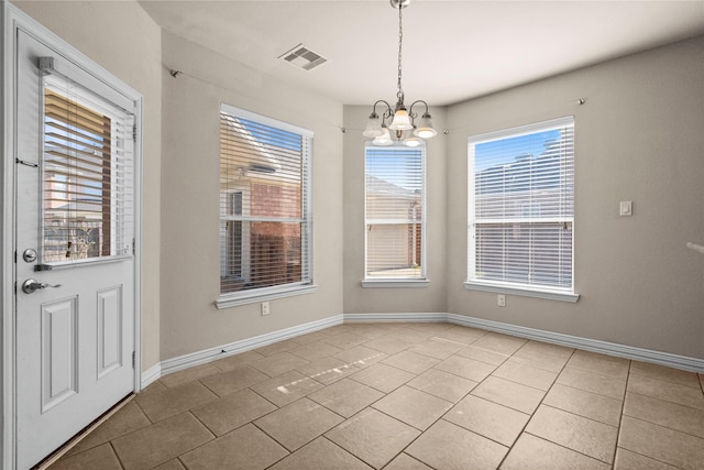 unfurnished dining area with a chandelier and light tile patterned floors