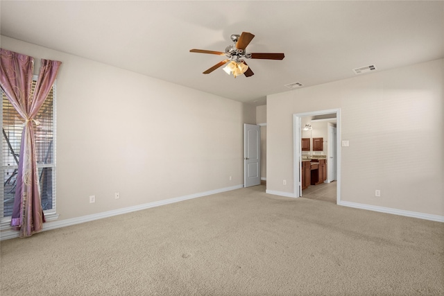 unfurnished bedroom with ceiling fan, connected bathroom, and light carpet