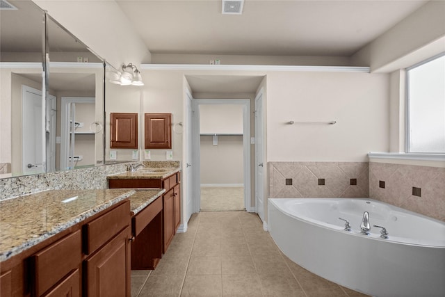 bathroom featuring tile patterned flooring, vanity, and a bathtub