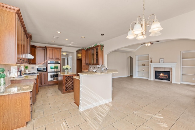 2511 Orchid Creek Dr, Pearland, TX 77584 - kitchen with appliances with stainless steel finishes, arched walkways, open floor plan, light tile patterned flooring, and a ceiling fan