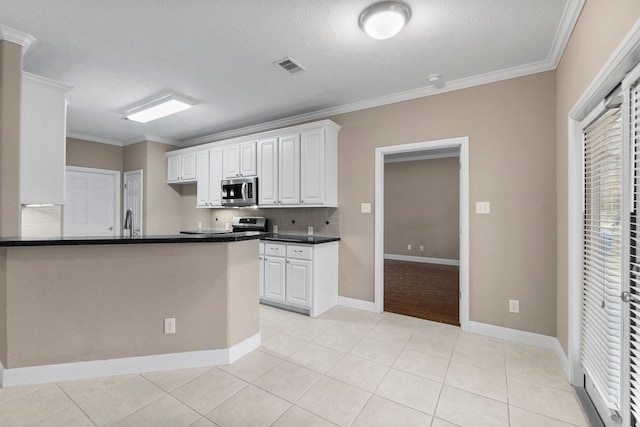 kitchen with white cabinetry, light tile patterned floors, ornamental molding, and kitchen peninsula