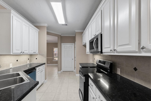 kitchen featuring sink, white cabinets, light tile patterned floors, stainless steel appliances, and crown molding