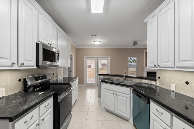 kitchen featuring light tile patterned floors, stainless steel appliances, sink, and white cabinets