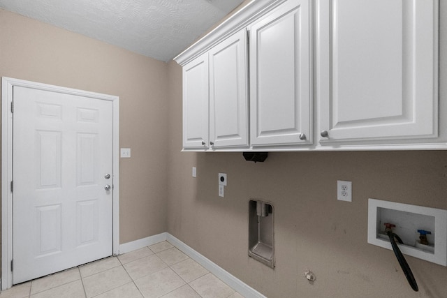 laundry room featuring cabinets, a textured ceiling, light tile patterned floors, hookup for a washing machine, and electric dryer hookup