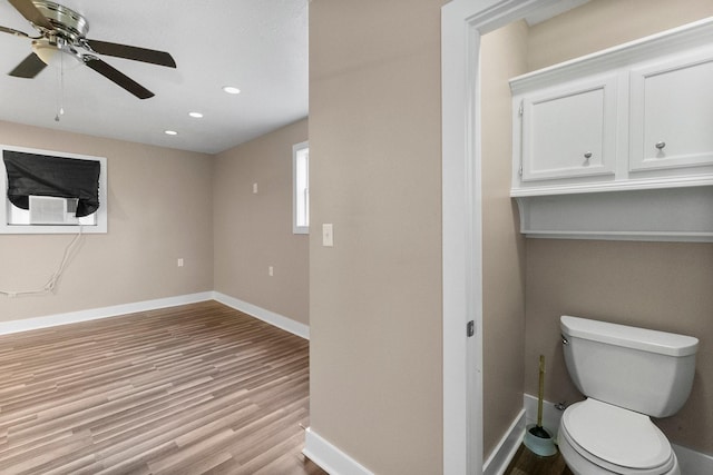 bathroom with hardwood / wood-style floors, toilet, and ceiling fan