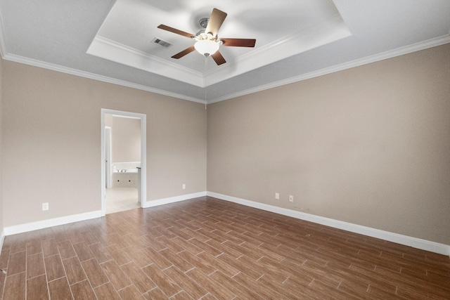 empty room featuring ceiling fan, ornamental molding, and a raised ceiling