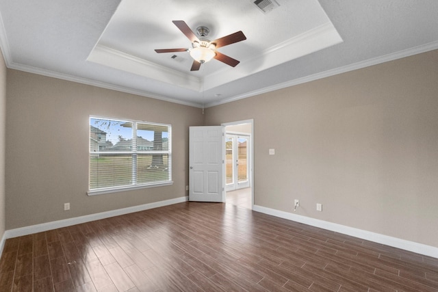 unfurnished room featuring dark hardwood / wood-style floors, ornamental molding, and a raised ceiling