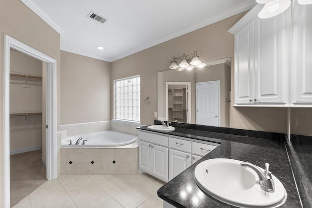 bathroom with crown molding, a relaxing tiled tub, tile patterned floors, and vanity