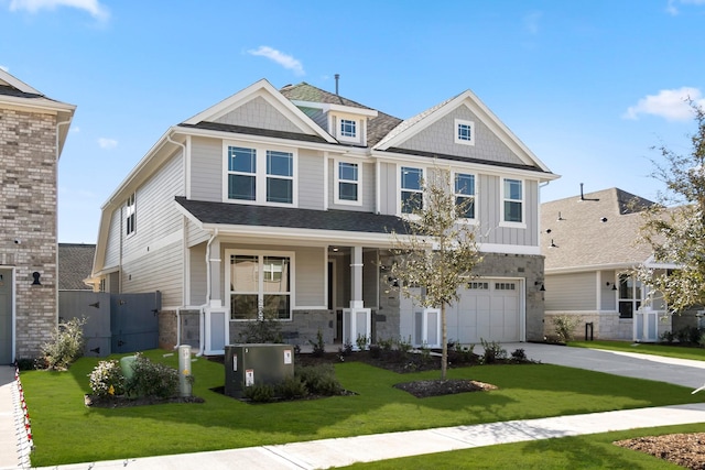 craftsman inspired home featuring a garage and a front lawn