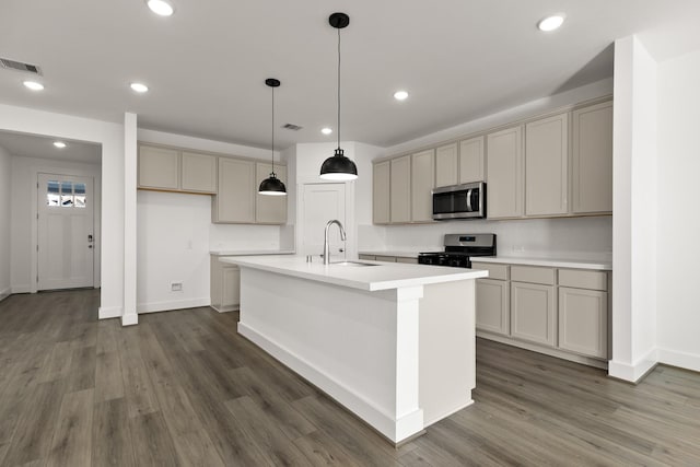 kitchen featuring appliances with stainless steel finishes, sink, dark hardwood / wood-style flooring, an island with sink, and gray cabinets