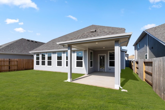 back of house with a yard and a patio