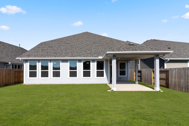 back of house with a lawn and a patio