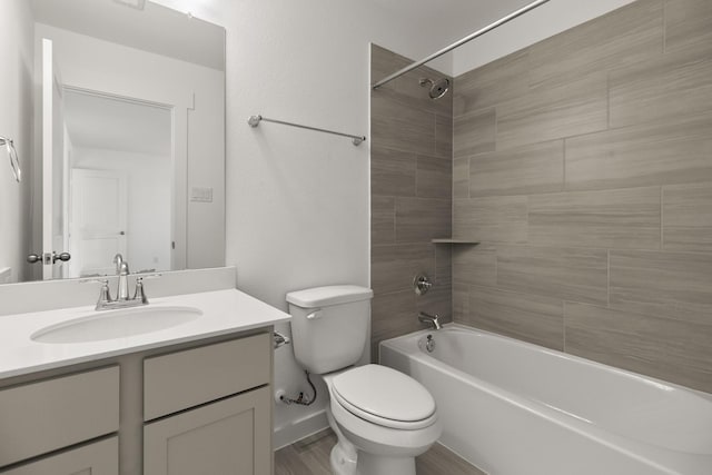 full bathroom featuring tiled shower / bath combo, vanity, and toilet