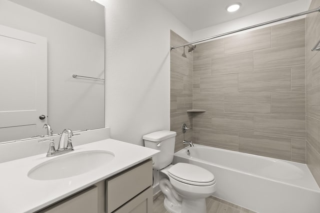 full bathroom featuring hardwood / wood-style floors, toilet, vanity, and tiled shower / bath combo