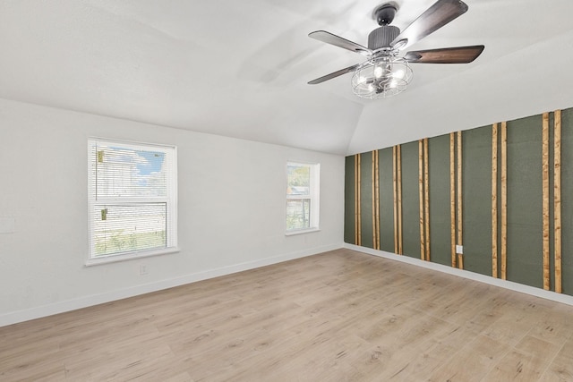 empty room featuring light wood-type flooring and vaulted ceiling