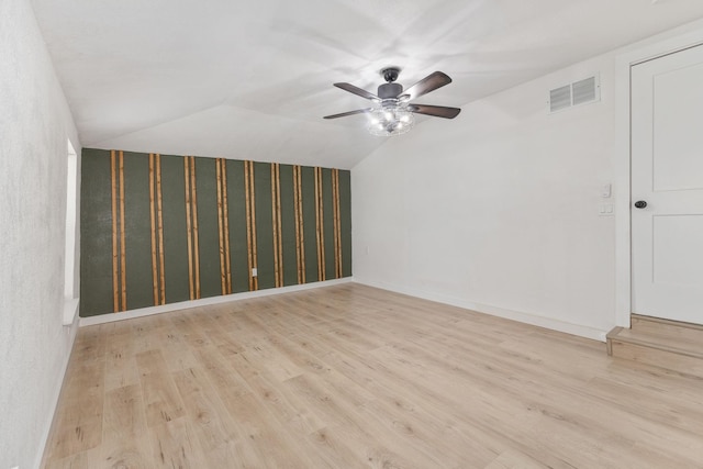 empty room featuring light hardwood / wood-style floors, ceiling fan, and vaulted ceiling