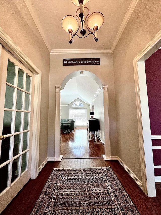 corridor with dark hardwood / wood-style flooring, decorative columns, ornamental molding, and lofted ceiling