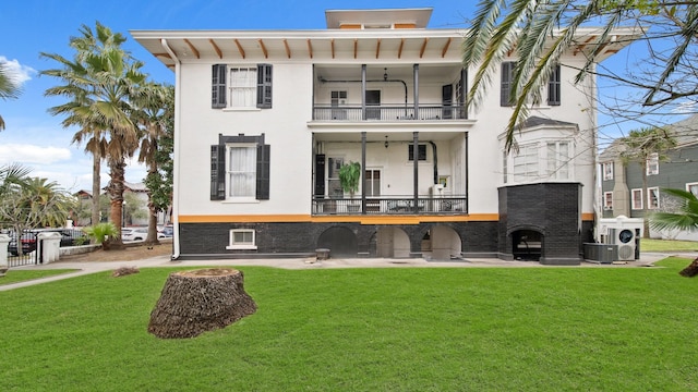 rear view of property with a balcony and a yard