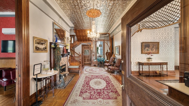 hallway featuring a chandelier, ornamental molding, and parquet floors