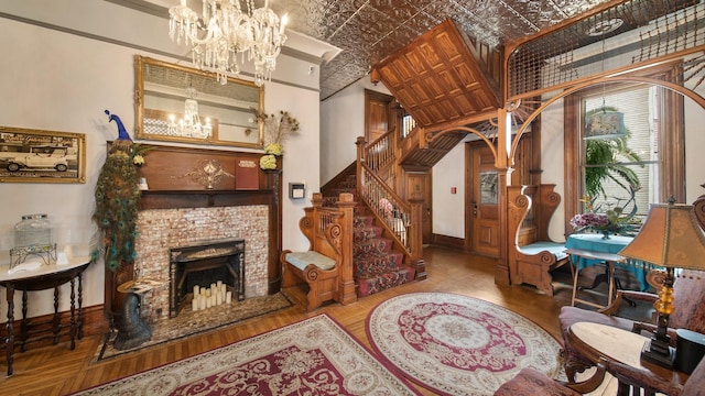 living room with brick ceiling, light wood-type flooring, a brick fireplace, and a notable chandelier