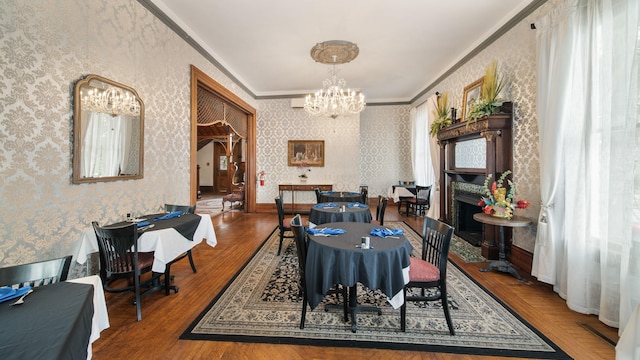 dining room with hardwood / wood-style floors, ornamental molding, and a notable chandelier