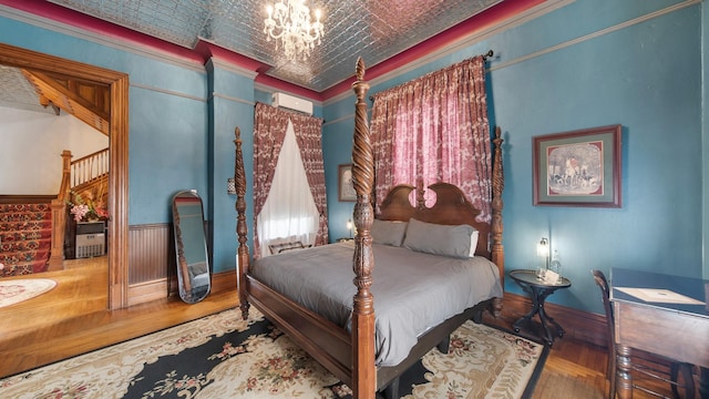 bedroom featuring hardwood / wood-style flooring, brick ceiling, crown molding, and a chandelier