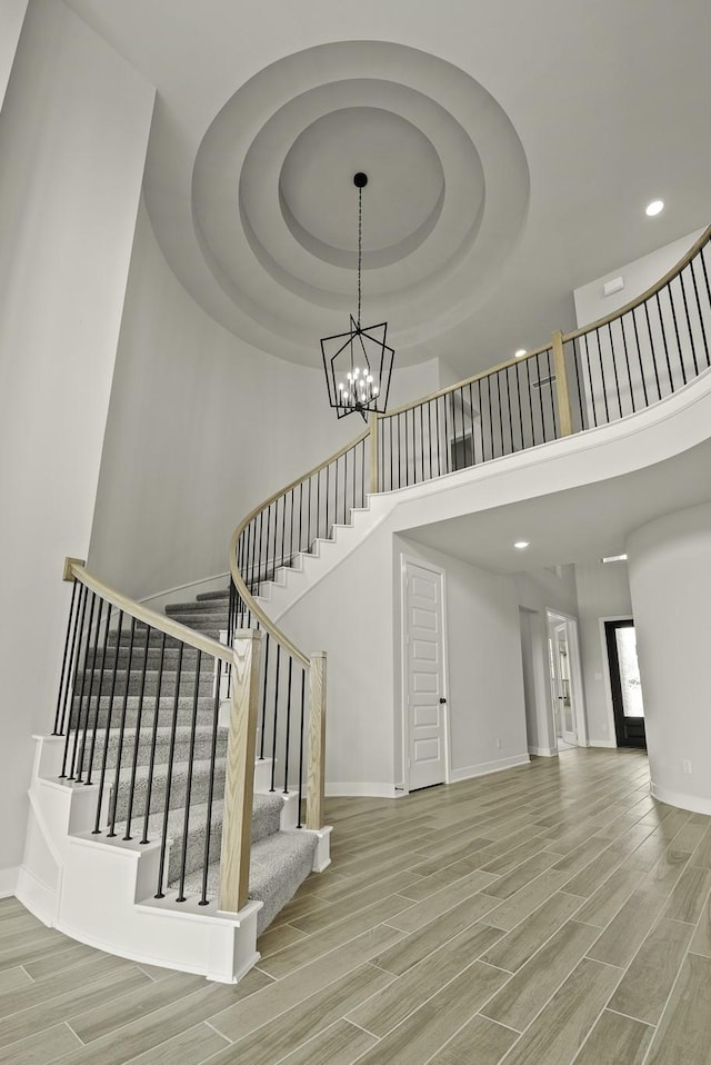 10807 Lighthouse Peak Trce, Richmond, TX 77406 - stairs featuring a chandelier, wood finished floors, baseboards, recessed lighting, and a towering ceiling