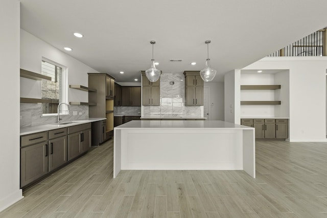 26515 Castra Crescent Trl, Richmond, TX 77406 - kitchen with open shelves, a sink, a kitchen island, recessed lighting, and light wood-style floors