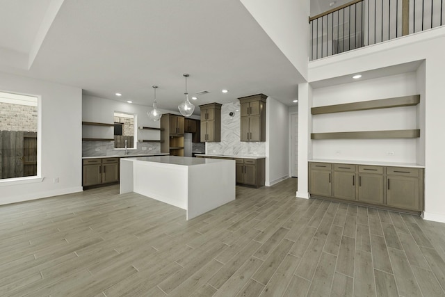 26515 Castra Crescent Trl, Richmond, TX 77406 - kitchen with open shelves, a kitchen island, recessed lighting, tasteful backsplash, and light wood-type flooring