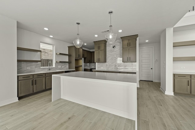 26515 Castra Crescent Trl, Richmond, TX 77406 - kitchen featuring open shelves, a sink, a center island, light wood-style flooring, and backsplash