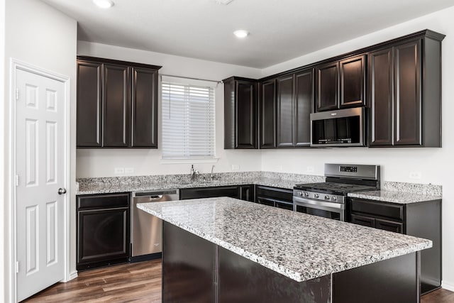 kitchen featuring dark brown cabinets, a center island, appliances with stainless steel finishes, and dark hardwood / wood-style flooring