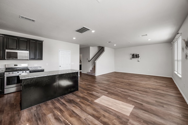 kitchen featuring light stone countertops, a center island, appliances with stainless steel finishes, and plenty of natural light