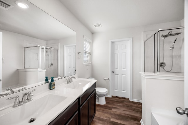 bathroom featuring vanity, a shower with shower door, toilet, and hardwood / wood-style flooring