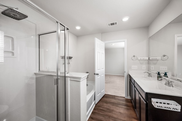 bathroom with hardwood / wood-style flooring, vanity, and shower with separate bathtub