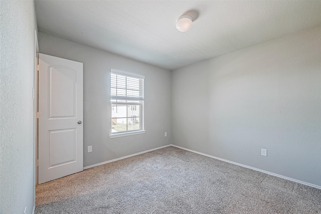 empty room with a textured ceiling and carpet flooring