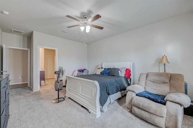 carpeted bedroom with ceiling fan and ensuite bath