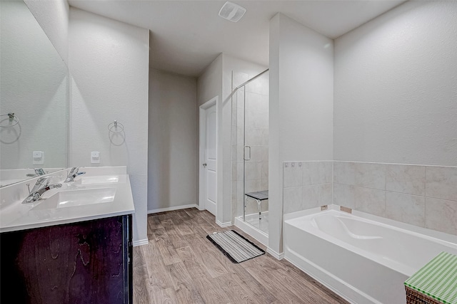 bathroom with vanity, hardwood / wood-style flooring, and plus walk in shower