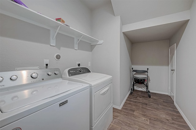 clothes washing area with washer and dryer and hardwood / wood-style flooring