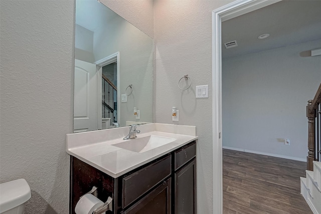 bathroom with hardwood / wood-style floors, toilet, and vanity