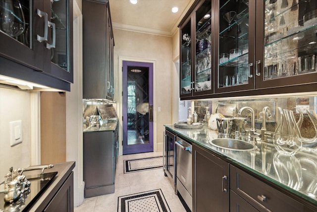 bar featuring sink, dark stone counters, and dark brown cabinetry