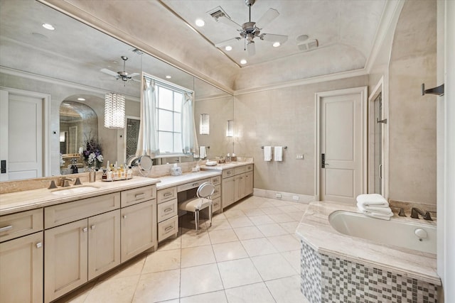 bathroom with ceiling fan, tiled bath, a tray ceiling, and vanity