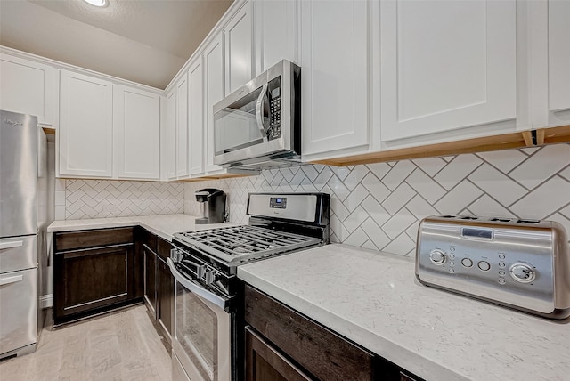 kitchen with white cabinetry, appliances with stainless steel finishes, and dark brown cabinetry