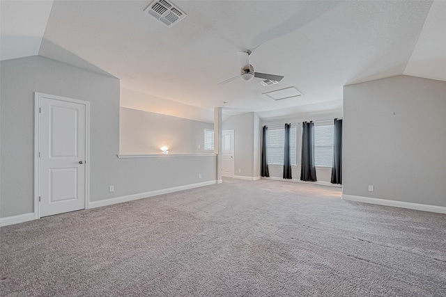 spare room featuring light carpet, a healthy amount of sunlight, and vaulted ceiling