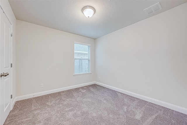 carpeted spare room with a textured ceiling