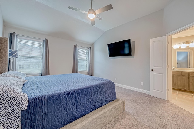 carpeted bedroom featuring ceiling fan, ensuite bathroom, and vaulted ceiling