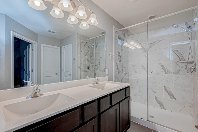 bathroom featuring vanity, a tile shower, and tile patterned flooring