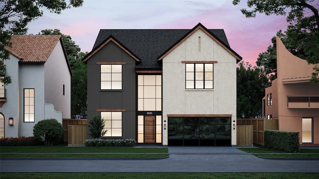 view of front facade with stucco siding, concrete driveway, a garage, and fence