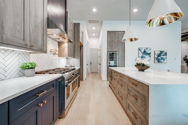 2231 Colquitt St, Houston, TX 77098 - kitchen featuring range with two ovens, decorative backsplash, light wood-style floors, recessed lighting, and a kitchen island