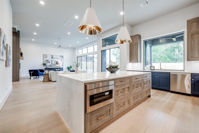 2231 Colquitt St, Houston, TX 77098 - kitchen with stainless steel dishwasher, plenty of natural light, light wood finished floors, light stone counters, and recessed lighting